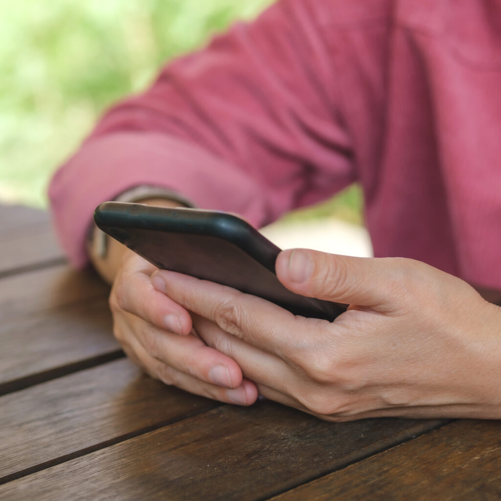 woman shopping online with credit card at coffee shop in outdoor.close up hand holding smartphone