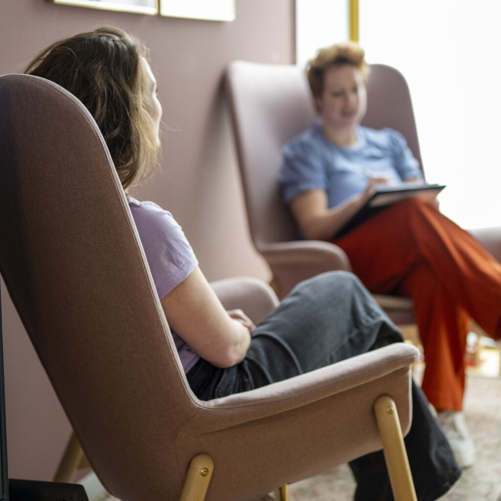 Two women engaged in an indoor conversation
